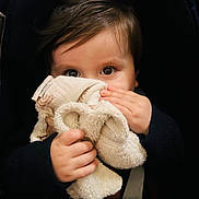 Gabriel a rejoint le concours — aidez-le/la à gagner de superbes lots ! child, baby, toddler, blanket, stuffed_toy, lovey, hands, eyes, face, hair, car_seat, seatbelt, portrait, close_up, cozy, soft_texture, cute, infant, grasping, plush