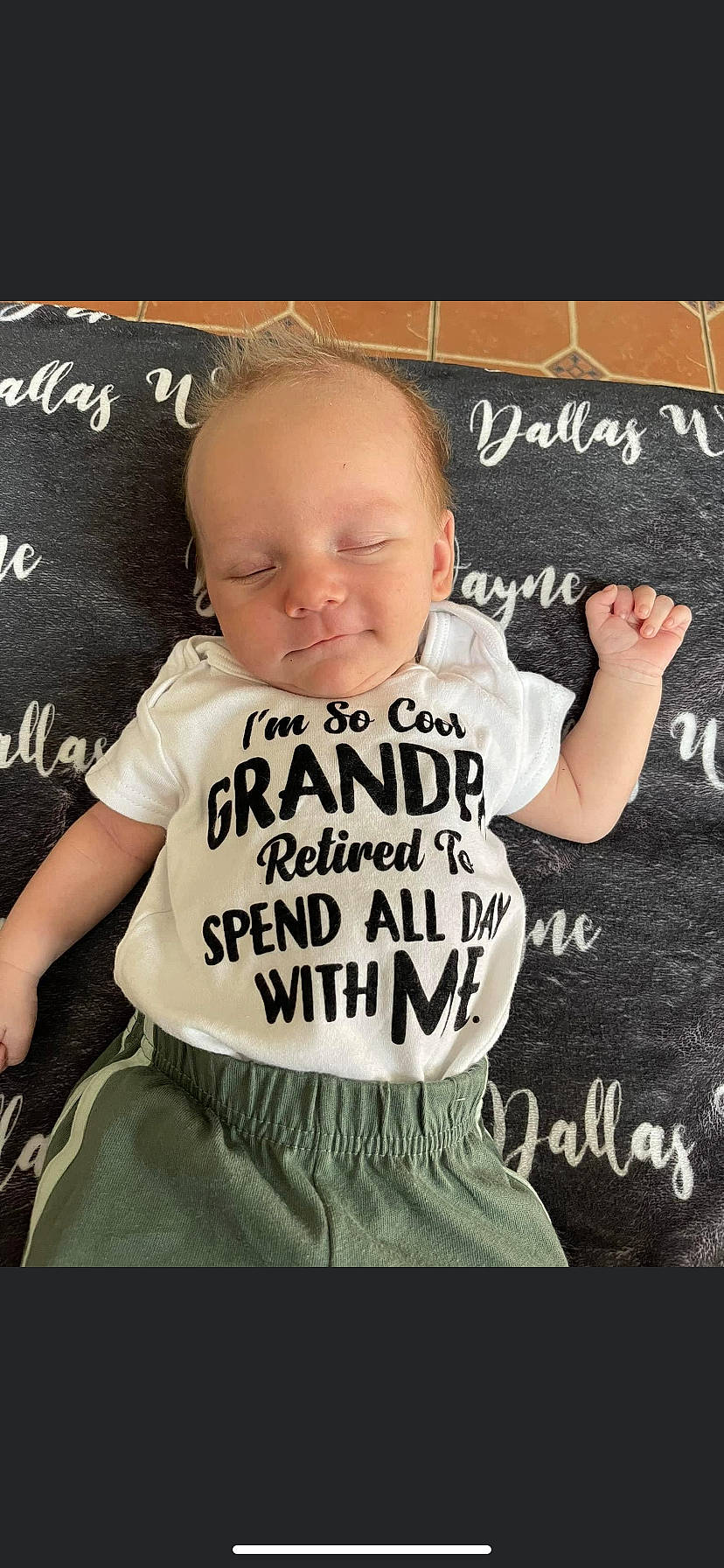 Dallas is registered to the contest to win money with this photo: baby, baby_toddler_clothing, blackboard, chalk, cheek, child, cool, font, fun, gesture, handwriting, happy, logo, person, photo_caption, room, sitting, sleeve, t_shirt, toddler