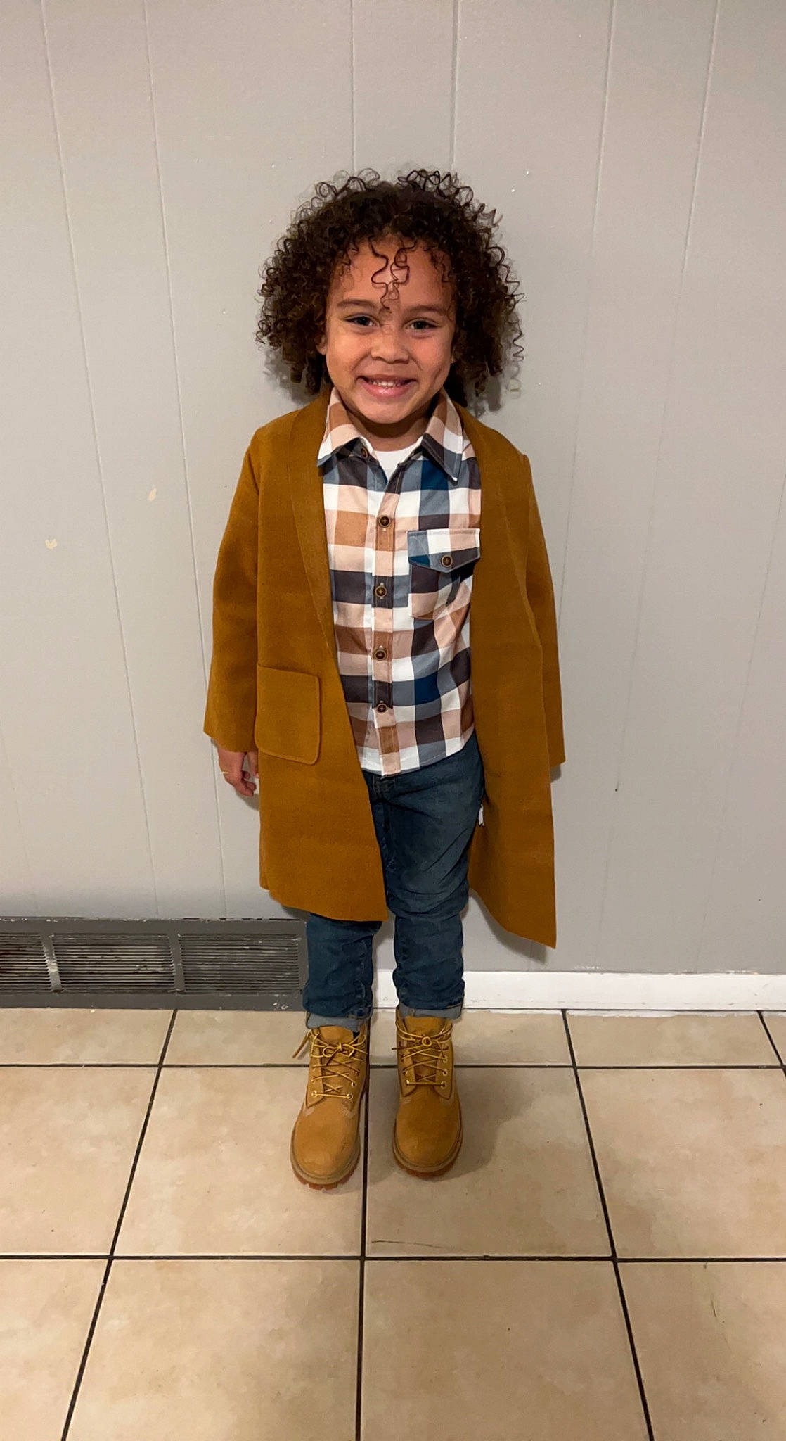 Amiri is registered to the contest to win money with this photo: bag, blazer, boot, collar, denim, dress_shirt, face, fashion_design, flooring, formal_wear, fur, jacket, joy, knee, pattern, person, plaid, scarf, sleeve, smile