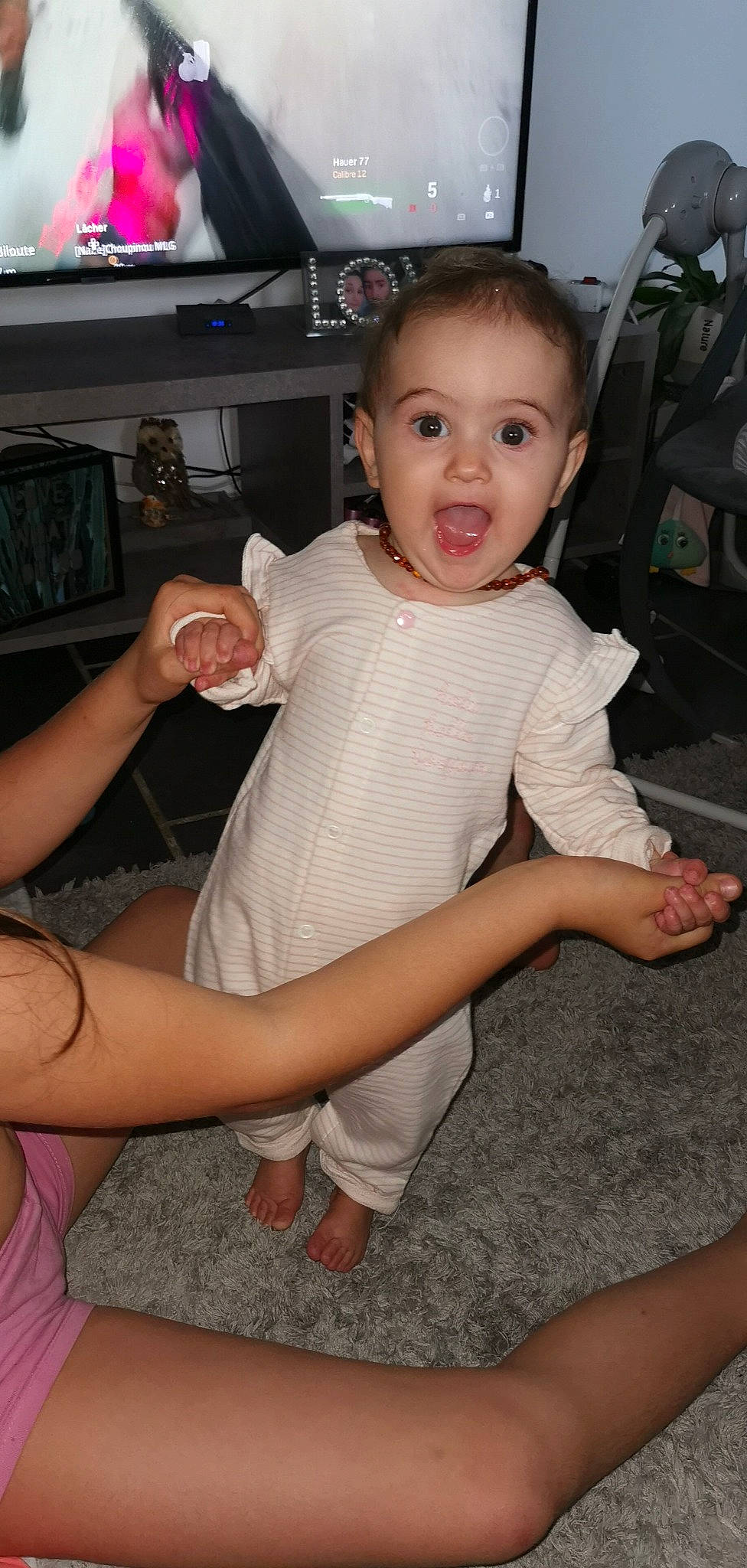 Lya participe au concours pour gagner de l'argent avec cette photo : baby_toddler_clothing, child, comfort, eye, face, flooring, fun, gesture, happy, human_leg, joint, knee, leg, person, shorts, skin, smile, surprise, thigh, thumb