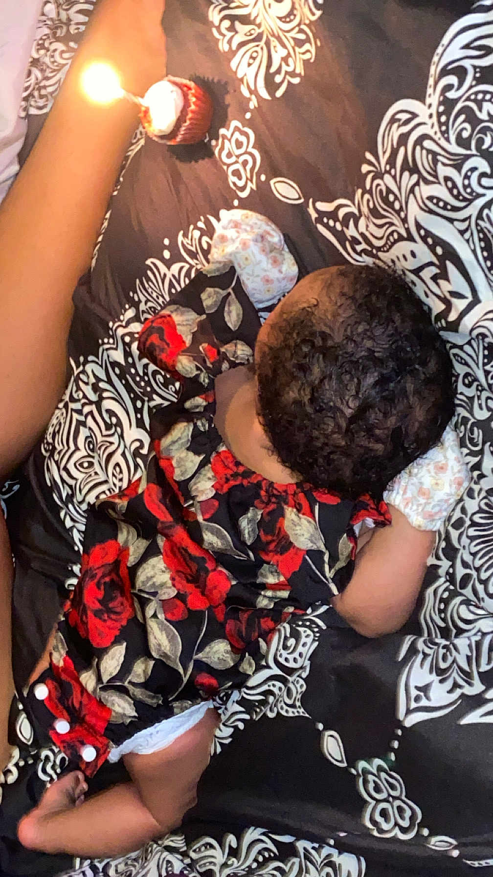 Jelaila joined the competition — help win amazing prizes! baby, infant, floral_clothing, blanket, birthday_candle, cupcake, pattern, sleeping, lying_down, arm, leg, diaper, curly_hair, celebration, bed, soft_lighting, close_up, indoors, child, cute