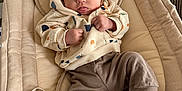 Sacha participe au concours pour gagner de l'argent avec cette photo : baby, infant, child, hoodie, socks, baby_seat, couch, fabric, indoor, person, cute, clothing, relaxing, soft, patterned, furniture, expression, tongue_out, home, cozy