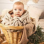 baby, blanket, basket, blue_eyes, cozy, cushion, face, furniture, greenery, handwoven, infant, indoors, light_skin, natural_light, person, plush, portrait, soft_texture, woven, wooden