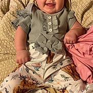 Olivia is registered to the contest to win money with this photo: baby, smiling, infant, clothing, patterned_pants, blanket, cute, happy, portrait, child, indoor, sleepwear, comfortable, young, ruffled_top, skin, face, hand, laying_down, expression