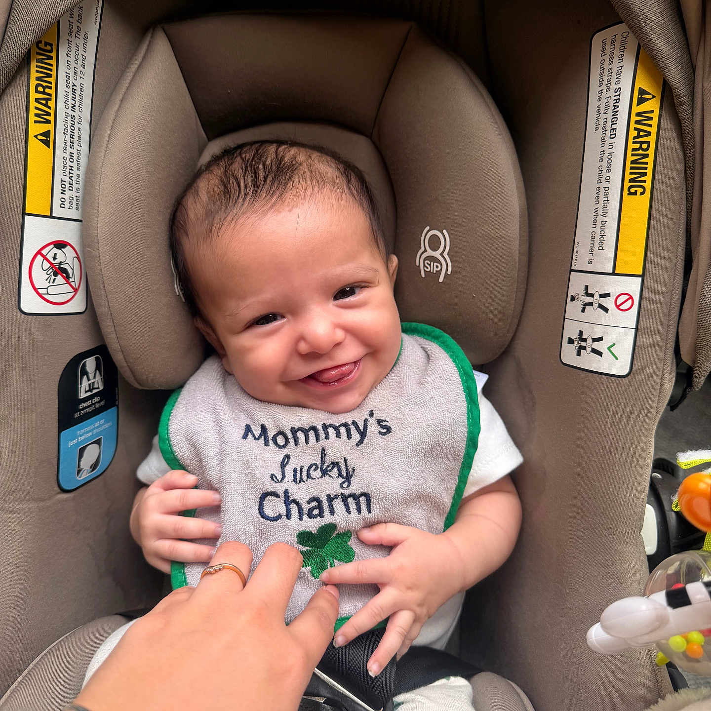 Easton is registered to the contest to win money with this photo: baby, bib, car_seat, child, clothing, cute, face, hand, happy, head, indoor, infant, person, seat, seatbelt, skin, smile, tickling, toddler, warning_label