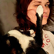 Dr. Venkman joined the competition — help win amazing prizes! cat, person, paw, face, winking, black_and_white_cat, human, close_up, indoor, bed, blanket, hair, nose_ring, expression, pet, affection, playful, fur, resting, casual_clothing