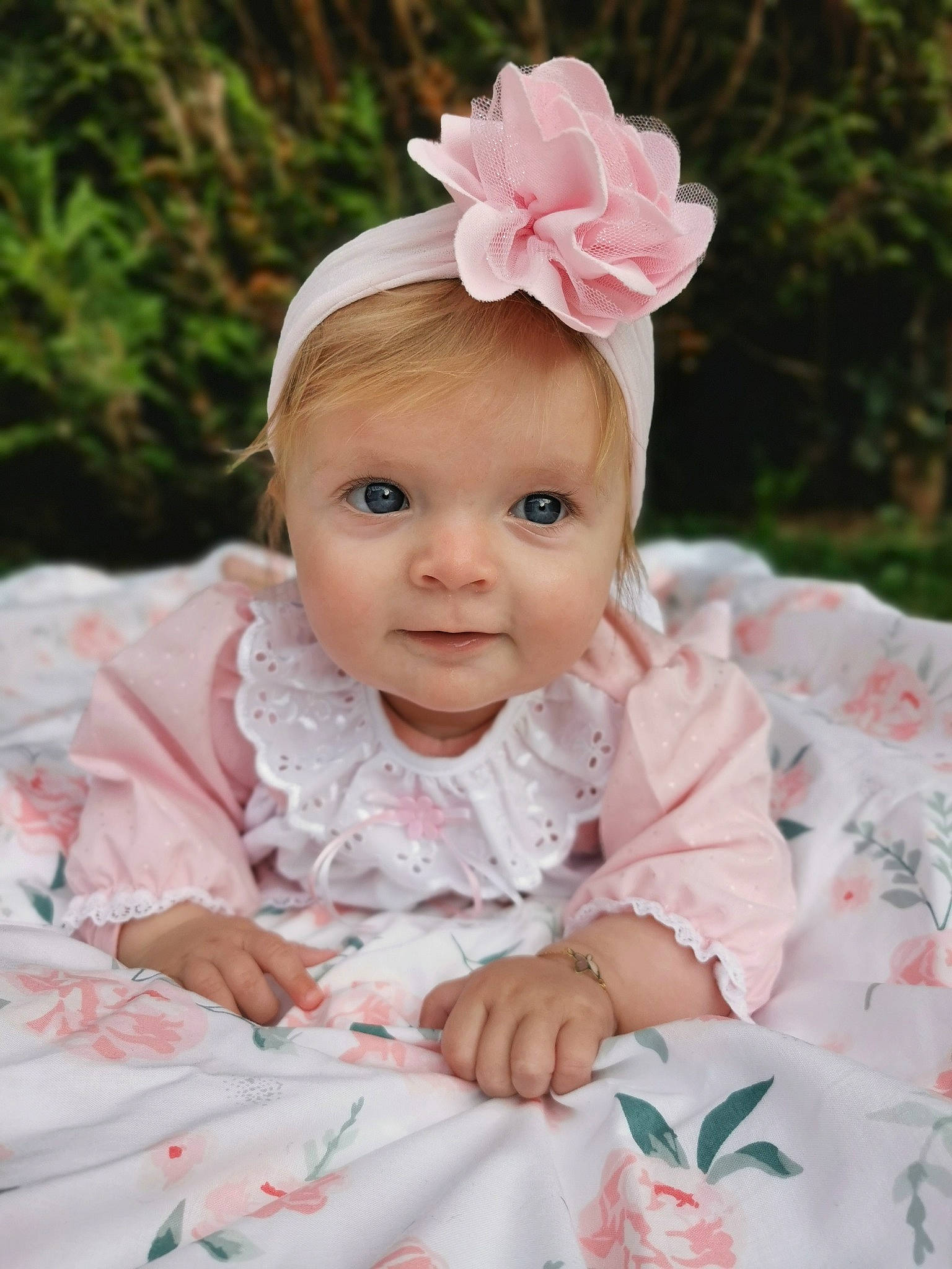 Esmée participe au concours pour gagner de l'argent avec cette photo : baby, baby_toddler_clothing, cheek, dress, embellishment, eye, flower, grass, happy, head, headband, headpiece, person, petal, pink, plant, sleeve, smile, textile, toddler