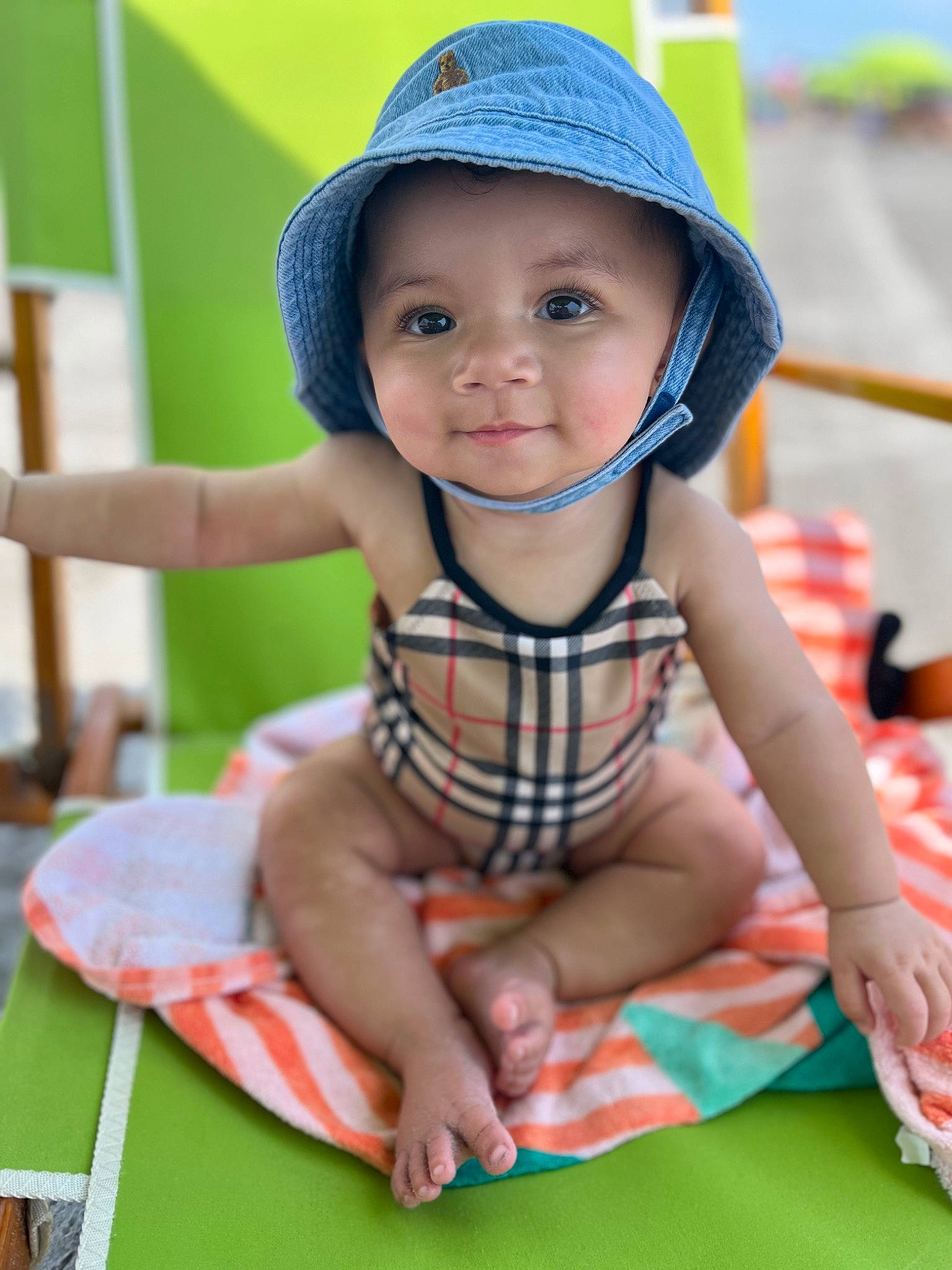 Brixley Sakura Kimberly is registered to the contest to win money with this photo: baby, cap, child, facial_expression, fun, grass, happy, hat, headgear, headwear, leisure, pattern, person, plaid, public_space, shorts, skin, smile, sun_hat, tartan