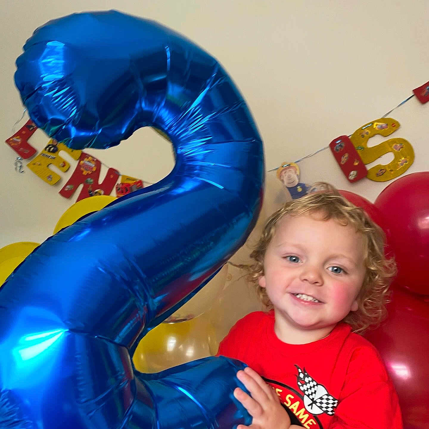Lennon is registered to the contest to win money with this photo: baby, ball, balloon, clothing, face, football, head, inflatable, number, people, person, photography, portrait, purple, soccer, soccerball, sport, symbol, t_shirt, text