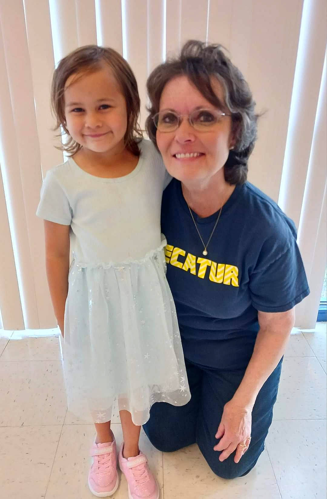 Olivia is registered to the contest to win money with this photo: child, event, flip_flops, foot, formal_wear, fun, gesture, glasses, happy, joint, joy, leg, person, sandal, shoulder, skin, sleeve, smile, standing, t_shirt