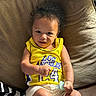 Jamar joined the competition — help win amazing prizes! baby, basketball_jersey, black_and_white_blanket, bright_lighting, child, couch, curly_hair, cushion, happy, home, indoors, infant, los_angeles, pacifier, portrait, relaxed, sitting, smiling, sportswear, yellow_jersey