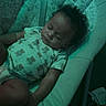 Jamar is registered to the contest to win money with this photo: baby, baby_seat, bear_print, bouncer, child, clothing, curly_hair, furniture, green_tint, indoors, infant, low_light, lying_down, nursery, onesie, patterned_fabric, peaceful, portrait, relaxed, sleeping