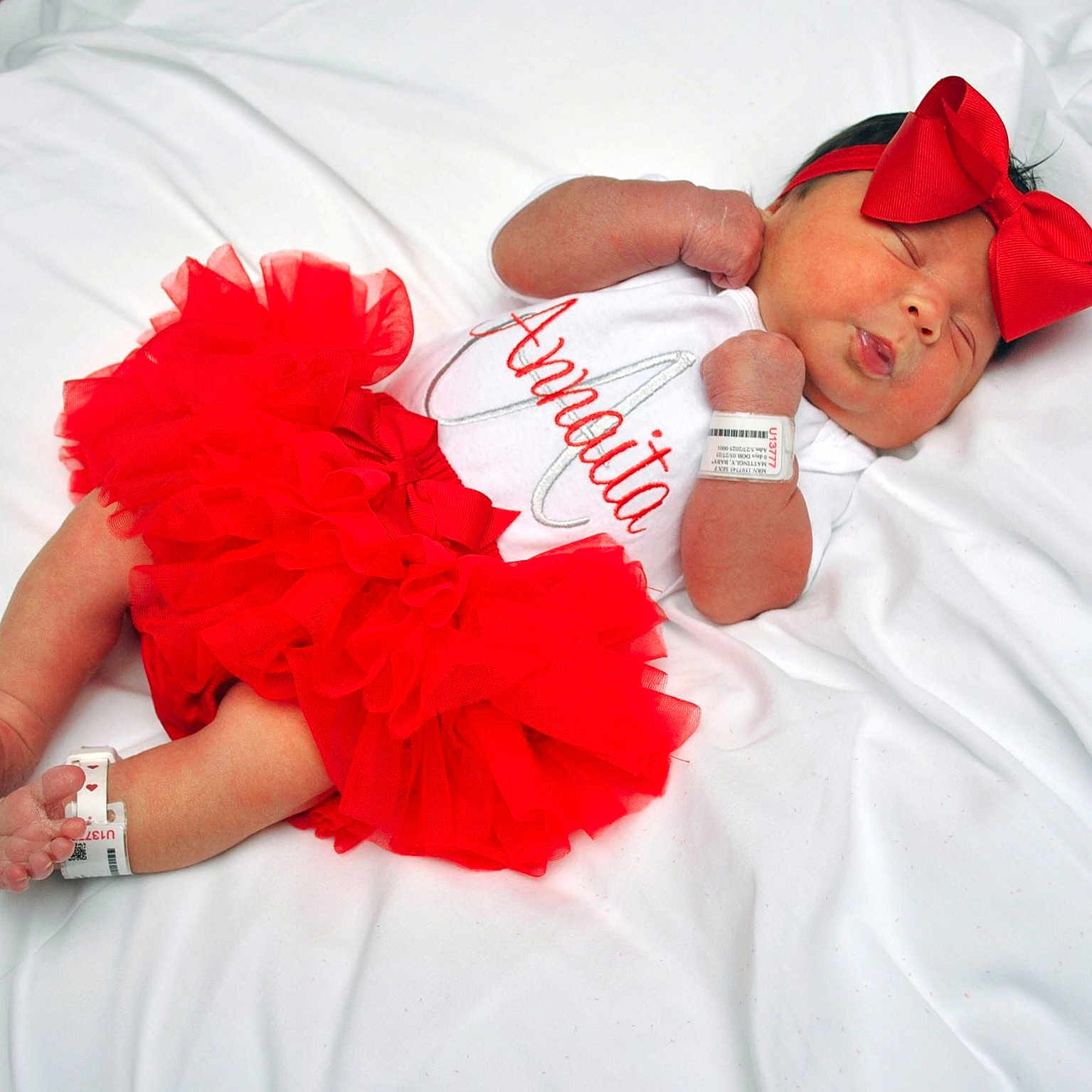Annaita joined the competition — help win amazing prizes! baby, closeup, cute, feet, hands, headband, hospital_id_band, indoors, infant, lying_down, newborn, peaceful, person, portrait, red_bow, red_tutu, skin, sleeping, soft_texture, white_blanket