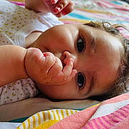 Kira participe au concours pour gagner de l'argent avec cette photo : baby, infant, thumb_sucking, close_up, curly_hair, blanket, striped_blanket, sleepwear, cute, child, face, skin, hand, lying_down, indoors, soft_light, expression, comfort, young_child, portrait