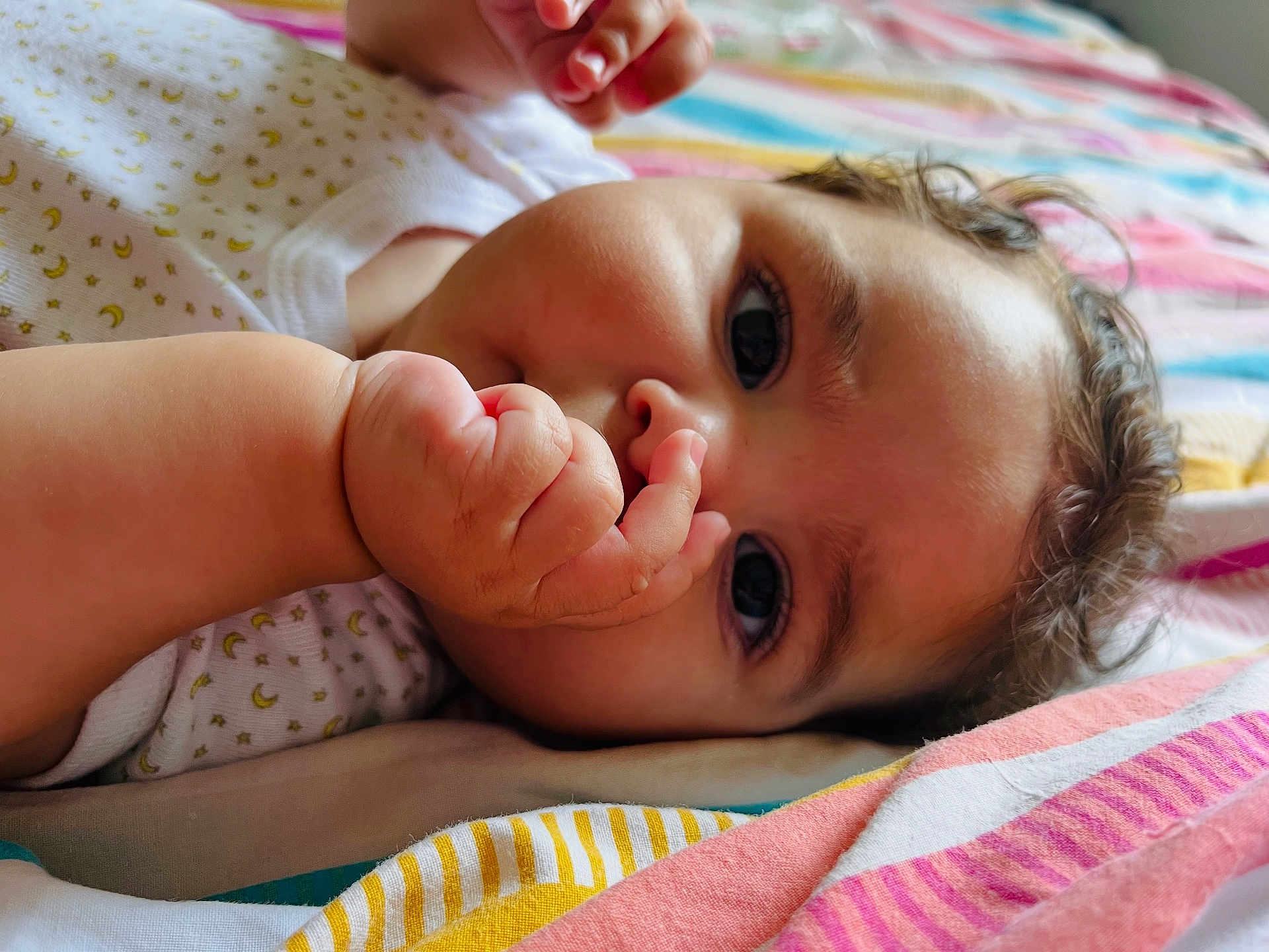 Kira participe au concours pour gagner de l'argent avec cette photo : baby, infant, thumb_sucking, close_up, curly_hair, blanket, striped_blanket, sleepwear, cute, child, face, skin, hand, lying_down, indoors, soft_light, expression, comfort, young_child, portrait