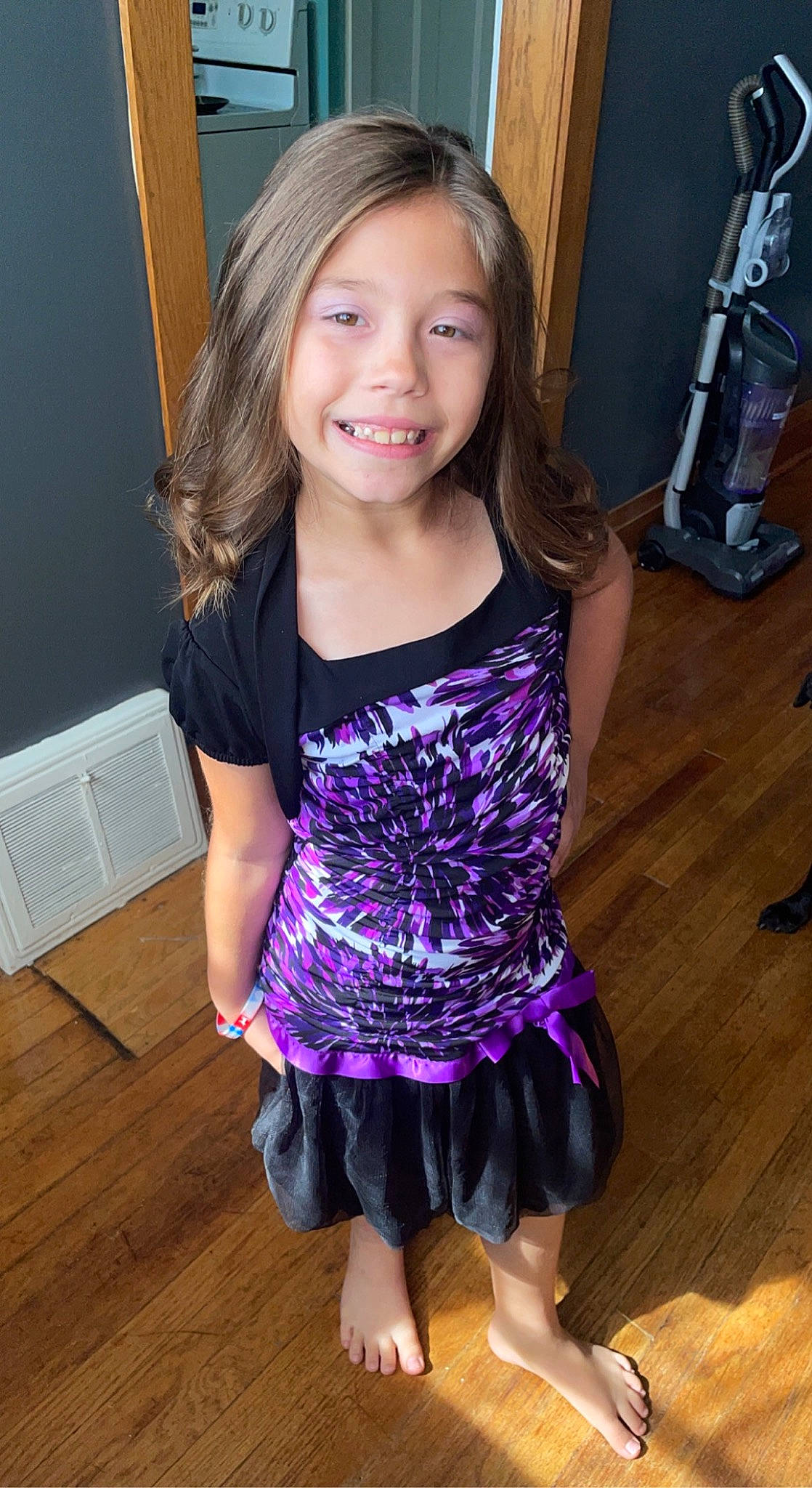 Sophia is registered to the contest to win money with this photo: baby_toddler_clothing, dress, floor, flooring, hair, happy, hardwood, head, human_body, iris, joy, leg, person, pink, purple, shoulder, sleeve, smile, thigh, trunk