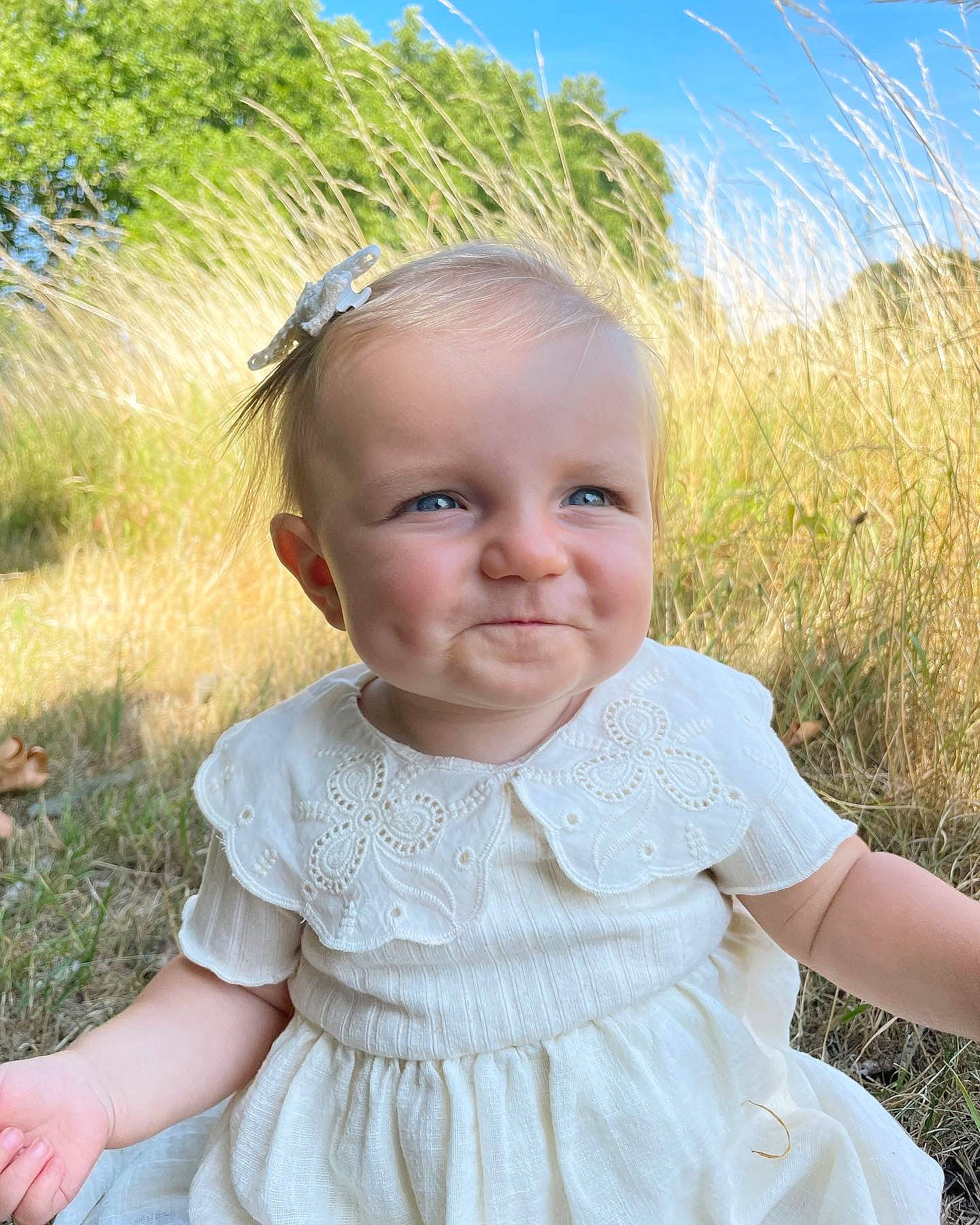 Arya a rejoint le concours — aidez-le/la à gagner de superbes lots ! baby, baby_toddler_clothing, blue, day_dress, embellishment, eye, grass, hair, happy, head, iris, joy, neck, pattern, people_in_nature, person, plant, skin, sky, sleeve