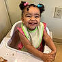 Amina joined the competition — help win amazing prizes! baby, bib, child, curly_hair, cute, eating, face, food, hair_beads, hands, happy, high_chair, indoor, meal, pink_clothing, room, skin, smiling, table, toddler