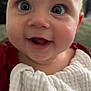Octavia is registered to the contest to win money with this photo: baby, close_up, face, eyes, mouth, smiling, infant, child, bib, red_clothing, indoor, portrait, happy, cute, skin, head, expression, young_child, person, soft_background