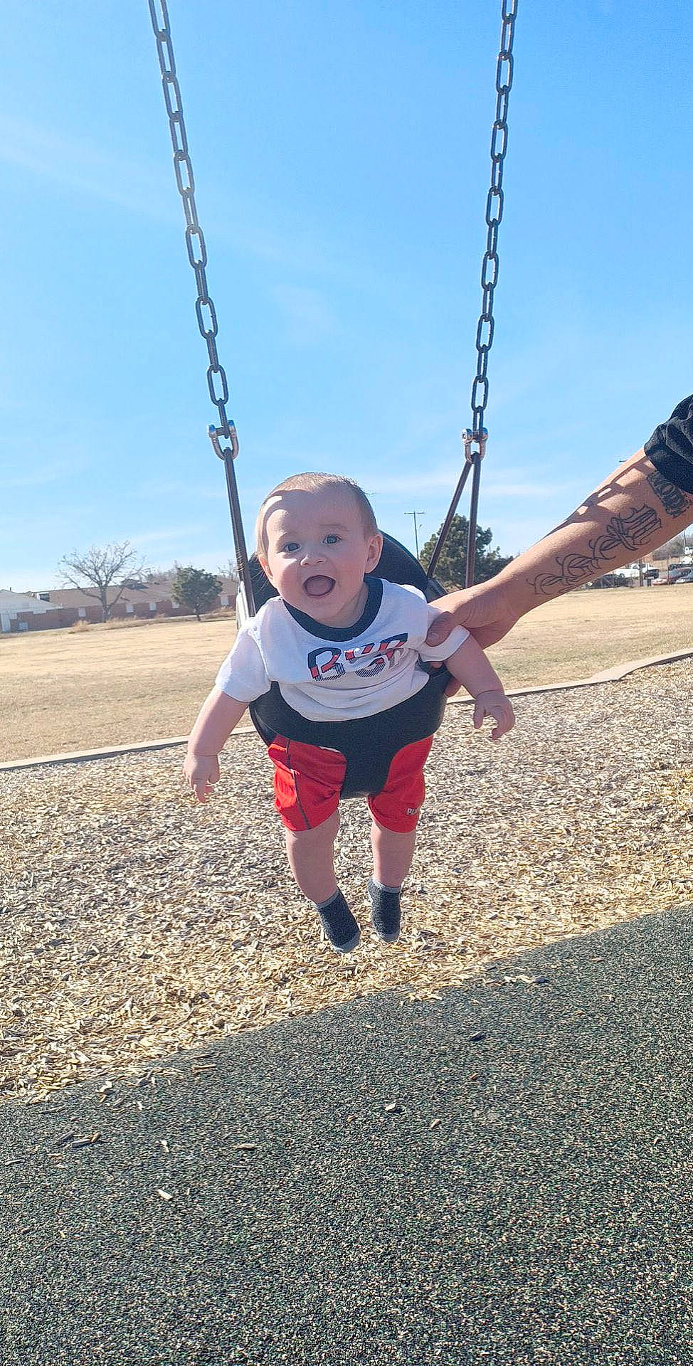 Matthias is registered to the contest to win money with this photo: city, cloud, electric_blue, fun, gesture, grass, happy, leisure, outdoor_play_equipment, people_in_nature, person, plant, play, playground, recreation, sky, soil, swing, thumb, toddler