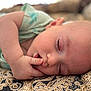 baby, sleeping, thumb_in_mouth, close_up, face, infant, blanket, pattern, soft_skin, peaceful, rest, child, cute, eyelashes, head, human, indoors, comfort, cozy, portrait
