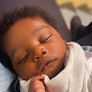 Nyjour is registered to the contest to win money with this photo: baby, sleeping, blanket, infant, face, hand, cozy, soft_light, portrait, closeup, indoors, peaceful, child, person, skin, curly_hair, newborn, wrapped, cute, resting