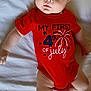 Ethan joined the competition — help win amazing prizes! baby, infant, red_onesie, 4th_of_july, fireworks_design, white_bed, lying_down, cute, curious, wide_eyes, child, clothing, celebration, holiday, portrait, skin, arms, legs, indoors, closeup