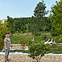 Léonardo participe au concours pour gagner de l'argent avec cette photo : child, boy, outdoor, garden, trees, grass, geese, birds, pebbles, plants, nature, summer, greenery, casual_clothing, cap, shorts, tshirt, walking, daytime, sky