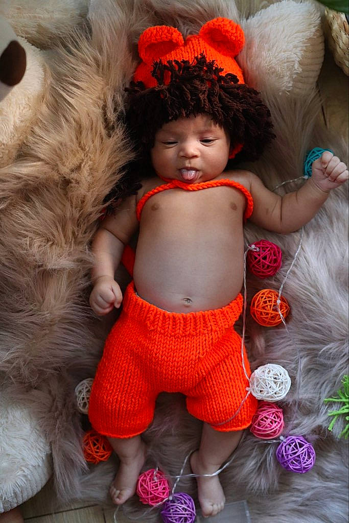 Zaki participe au concours pour gagner de l'argent avec cette photo : arm, baby_toddler_clothing, cap, doll, eye, fashion, fawn, hairstyle, hand, headgear, human_body, joint, orange, person, pink, skin, textile, thigh, toy, trunk