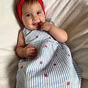 Vicenta a rejoint le concours — aidez-le/la à gagner de superbes lots ! baby, child, smiling, headband, red, dress, striped, strawberry_pattern, hand, finger, lying, blanket, soft, cute, happy, portrait, indoors, skin, face, eyes