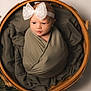 baby, newborn, wrapped, blanket, headband, bow, basket, wooden_basket, curious, infant, cute, portrait, soft_lighting, cozy, baby_boy, baby_girl, child, studio, posing, smile