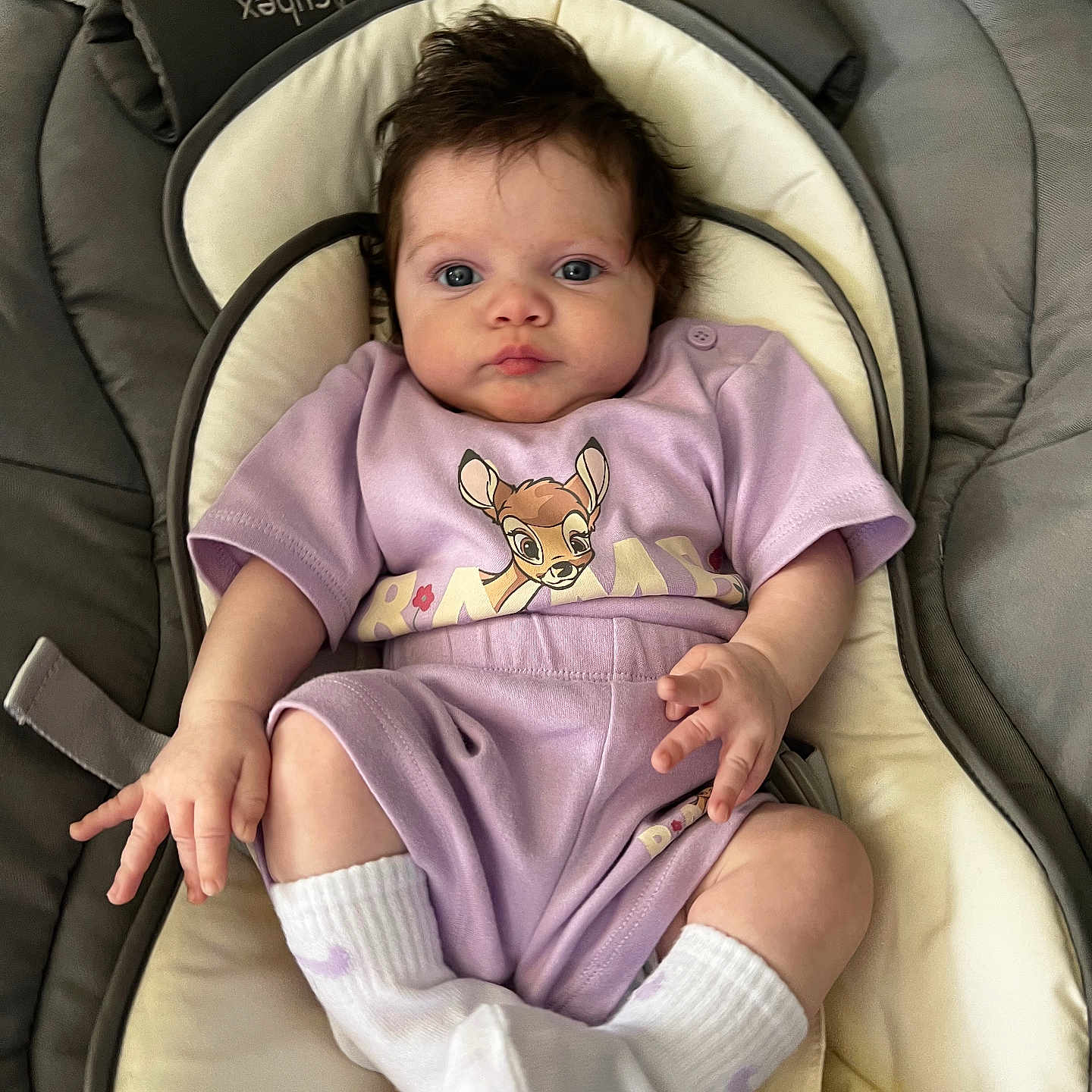 Novah is registered to the contest to win money with this photo: baby, baby_seat, child, clothing, comfort, cushion, cute, expression, face, hair, indoors, infant, person, portrait, purple_clothing, relaxing, seat, smiling, socks, toddler