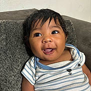 Yiannis joined the competition — help win amazing prizes! baby, child, clothing, couch, cushion, cute, expression, eyes, face, hair, happy, indoor, infant, person, portrait, relaxed, skin, smiling, striped_shirt, young