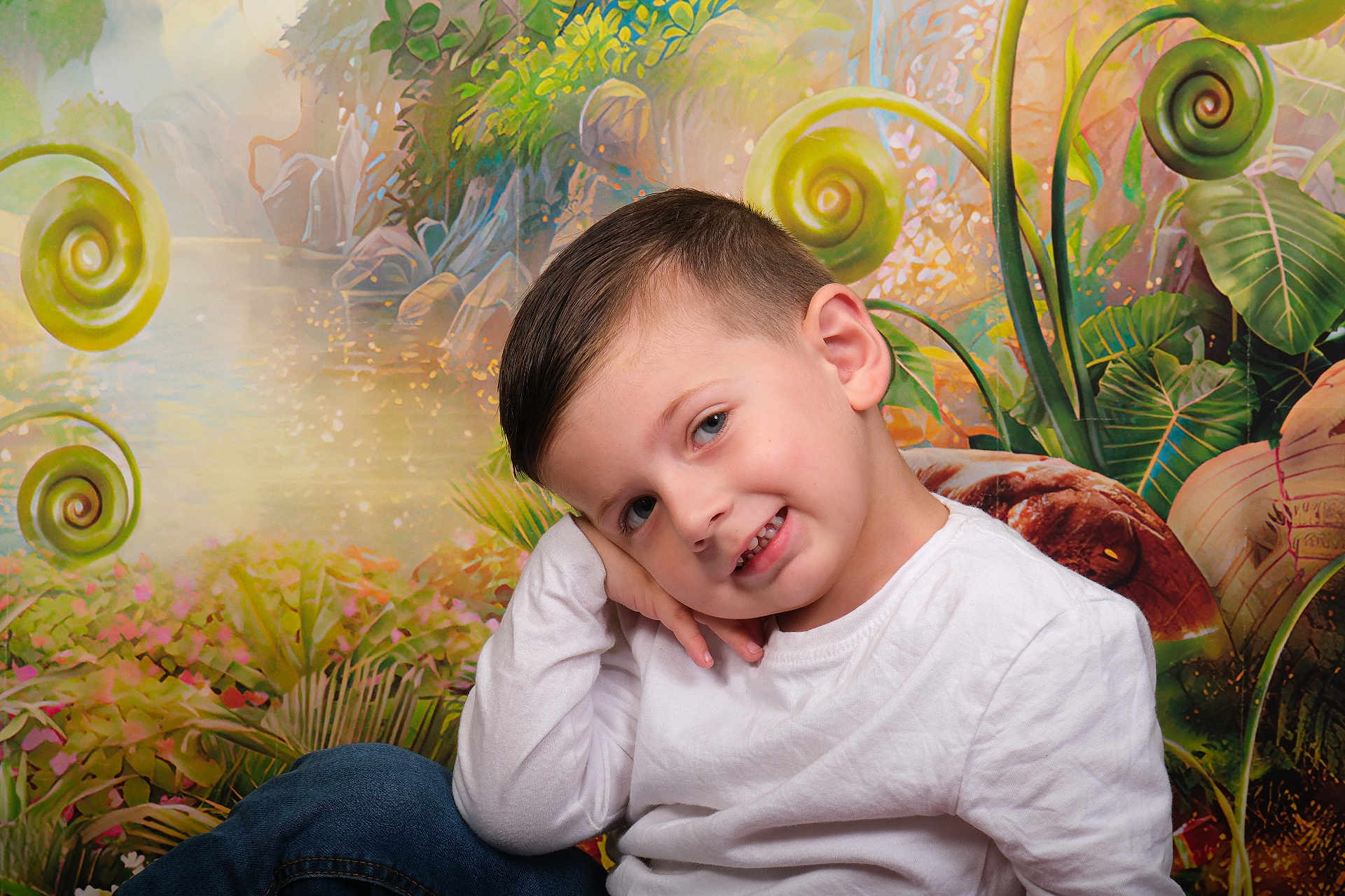 Julian a rejoint le concours — aidez-le/la à gagner de superbes lots ! child, boy, portrait, pose, white_shirt, blue_jeans, smile, face, hair, nature_background, plants, greenery, colorful, whimsical, cute, young, studio_photo, casual_clothing, happy, resting_head