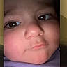 child, toddler, face, selfie, close_up, portrait, expression, curious, pouty, skin, eyes, nose, mouth, phone_screen, technology, indoors, purple_clothing, baby, person, photography