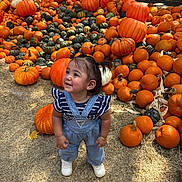 Alejandra is registered to the contest to win money with this photo: toddler, child, pumpkins, autumn, outdoor, hay, smiling, happy, overalls, denim, shoes, festival, fall, orange, green, nature, person, cute, playful, seasonal