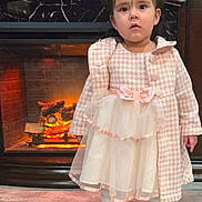 Alayah joined the competition — help win amazing prizes! child, clothing, coat, dress, fireplace, floor, girl, hair_bows, home, indoor, person, portrait, serious_expression, shoes, standing, tights, tile_floor, warmth, wood, young_child