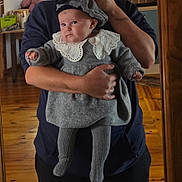 Laïa participe au concours pour gagner de l'argent avec cette photo : baby, child, person, mirror, reflection, holding, grey_clothing, lace_collar, hat, adult, hand, wooden_floor, indoor, home, portrait, cute, warm_lighting, cozy, tights, knitwear