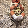 Grayson is registered to the contest to win money with this photo: baby, child, smiling, laughing, overalls, white_socks, lying_down, bedspread, floral_pattern, happy, infant, cute, fabric, clothing, person, indoors, skin, head, hands, feet