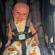 Grayson joined the competition — help win amazing prizes! baby, smiling, stroller, child, infant, happy, clothing, lion_pattern, seatbelt, cute, person, safety_harness, small_child, fabric, infant_clothes, head, face, tongue_out, sitting, indoors
