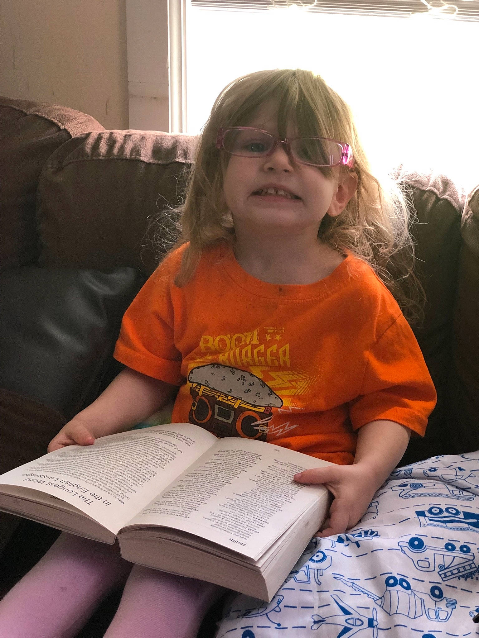 Ellieanna is registered to the contest to win money with this photo: child, couch, homework, person, reading, sitting