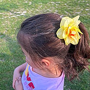 Kenza participe au concours pour gagner de l'argent avec cette photo : child, flower, hair_accessory, outdoor, grass, young_girl, purple_shirt, standing, daylight, nature, casual_clothing, hair, person, summer, greenery, cute, side_view, childhood, playful, sunlight