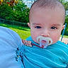 baby, pacifier, child, blue_clothing, outdoor, park, grass, trees, person, closeup, face, head, infant, daylight, nature, holding, serious, portrait, cute, young