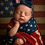 baby, infant, sleeping, flag, american_flag, patriotic, headband, bow, wrapped, portrait, closeup, peaceful, cute, face, hand, skin, child, background, red, blue