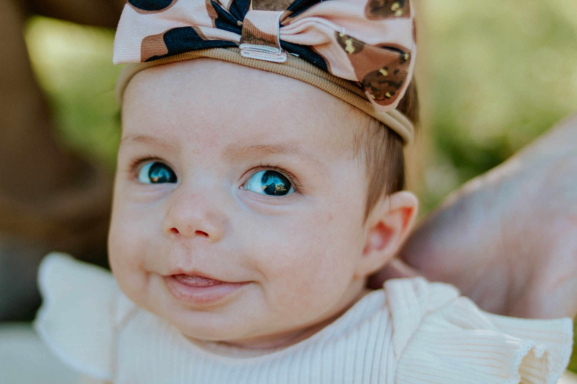 Oakleigh joined the competition — help win amazing prizes! baby, infant, face, headband, smile, cute, child, portrait, closeup, eyes, expression, clothing, white, skin, person, young, happy, outdoor, head, baby_girl