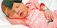 Amy is registered to the contest to win money with this photo: adorable, baby, bow, child, closeup, cute, hand, headband, indoors, infant, newborn, peaceful, pink_clothing, portrait, resting, skin, sleeping, soft_bedding, toddler, young