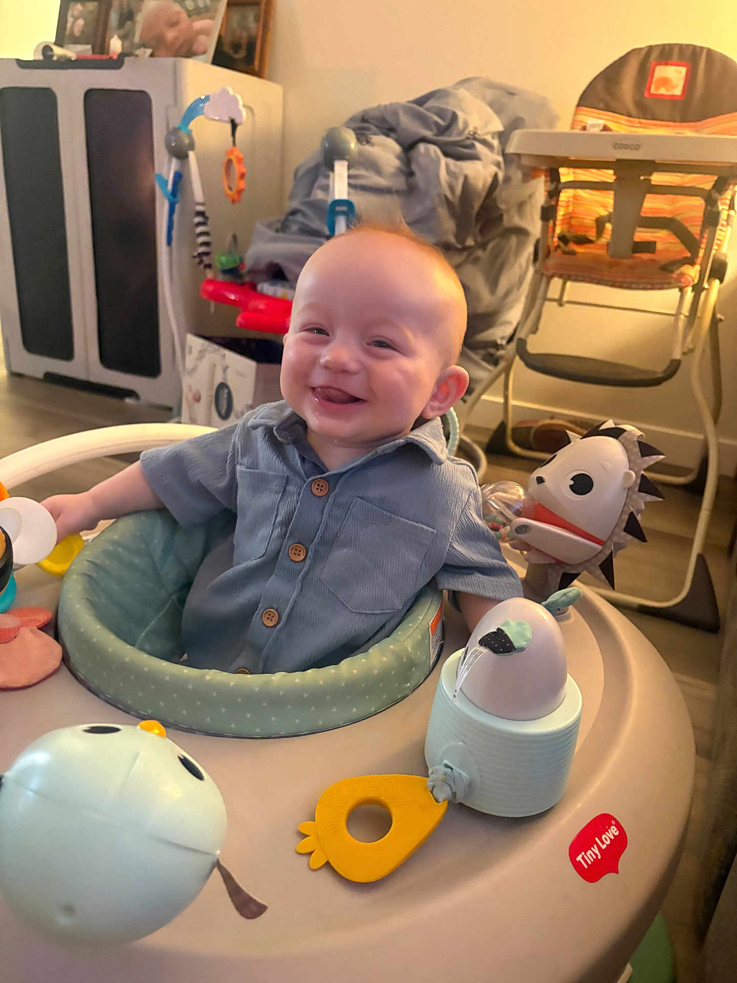 Ryker joined the competition — help win amazing prizes! baby, infant, smiling, sitting, activity_center, toy, play, button_shirt, face, eyes, mouth, drool, indoor, nursery, highchair, stroller, cabinet, blanket, furniture, happy