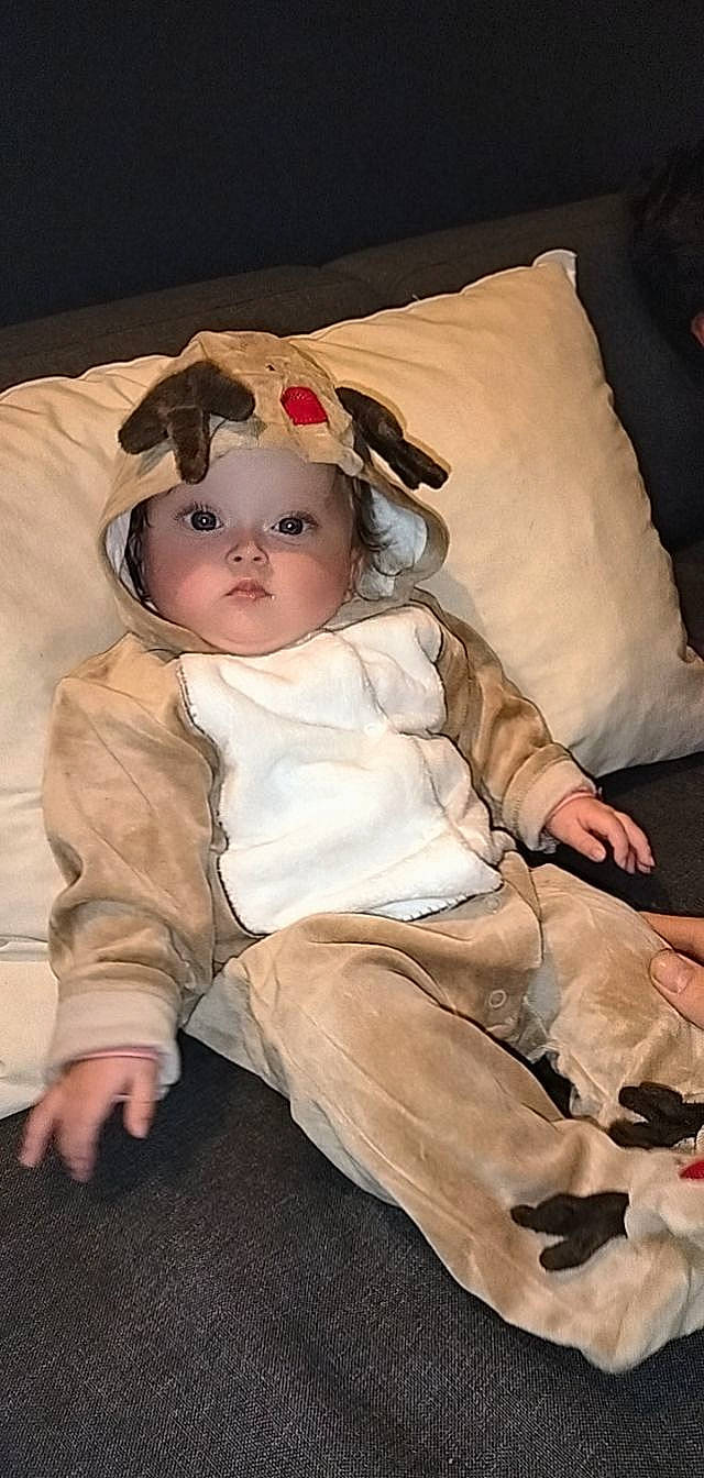 Melyana a rejoint le concours — aidez-le/la à gagner de superbes lots ! baby, baby_toddler_clothing, brown_hair, cheek, chin, comfort, eye, eyebrow, flooring, fur, head, headwear, iris, lip, person, pillow, sitting, skin, sleeve, textile