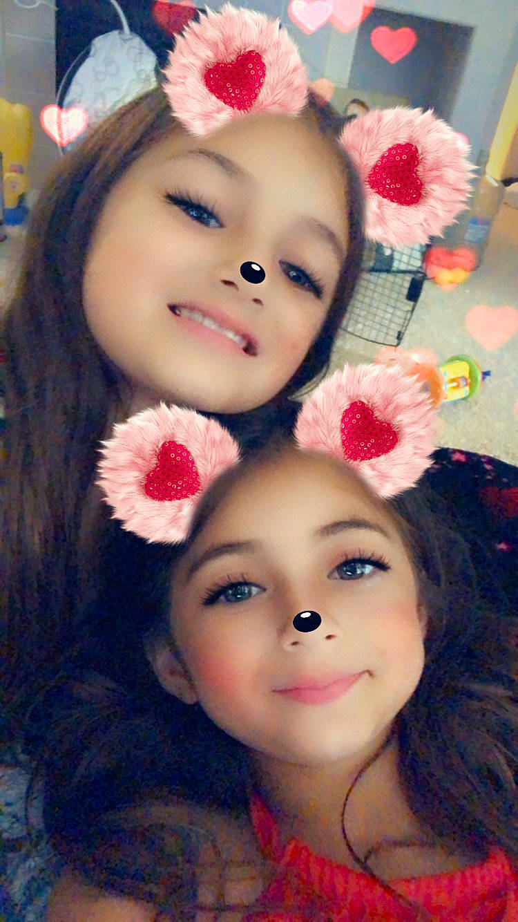 Seraphina is registered to the contest to win money with this photo: cheek, child, eye, eyebrow, eyelash, face, flower, hair_accessory, head, headwear, joy, lip, nose, person, pink, plant, smile