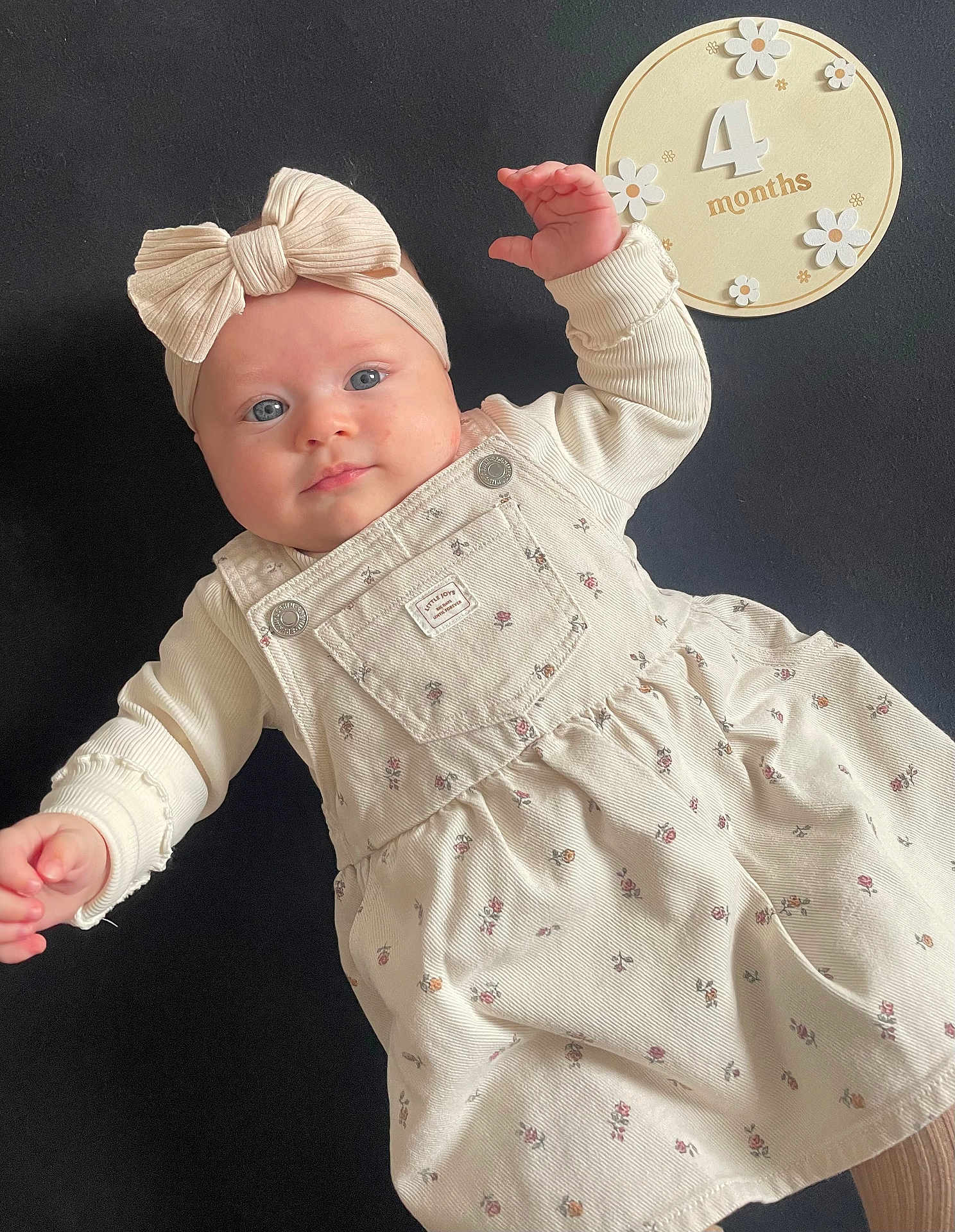 Aimée a rejoint le concours — aidez-le/la à gagner de superbes lots ! baby, infant, child, dress, headband, bow, blue_eyes, cute, portrait, laying_down, floral_pattern, soft_lighting, cream_color, 4_months, hand, face, skin, closeup, young, adorable